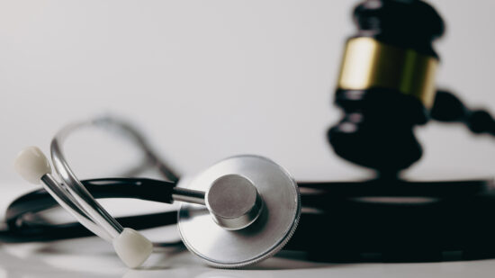 Stethoscope and gavel on white background, symbol of law and medic