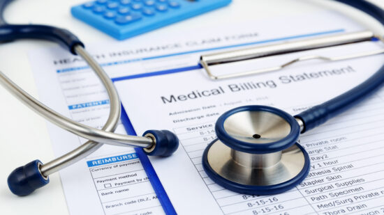 Stethoscope on medical bills and health insurance claim form